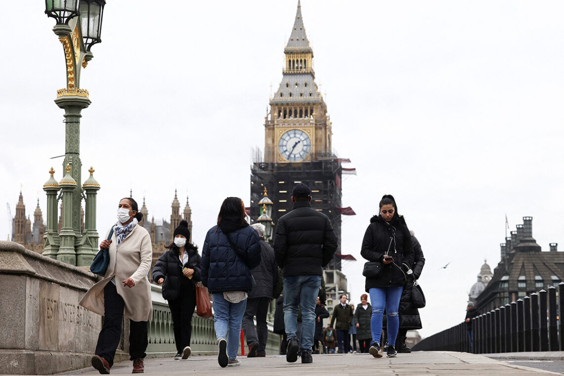 People wearing protective face masks walk over Westminster Bridge in front of the Elizabeth Tower, more commonly known as Big Ben, in London, Britain, December 15, 2021. REUTERS/Henry Nicholls
